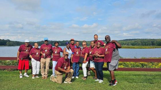 The First Baptist Church family in matching maroon church shirts by the lake