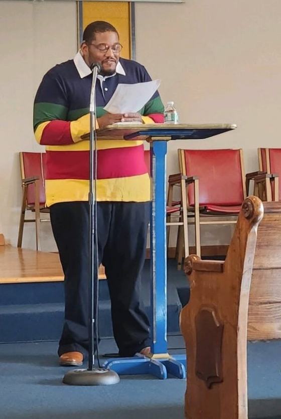 Nick reading at the lectern in the sanctuary