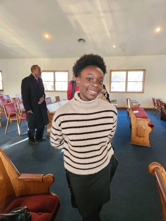 A smiling young lady standing in the sanctuary