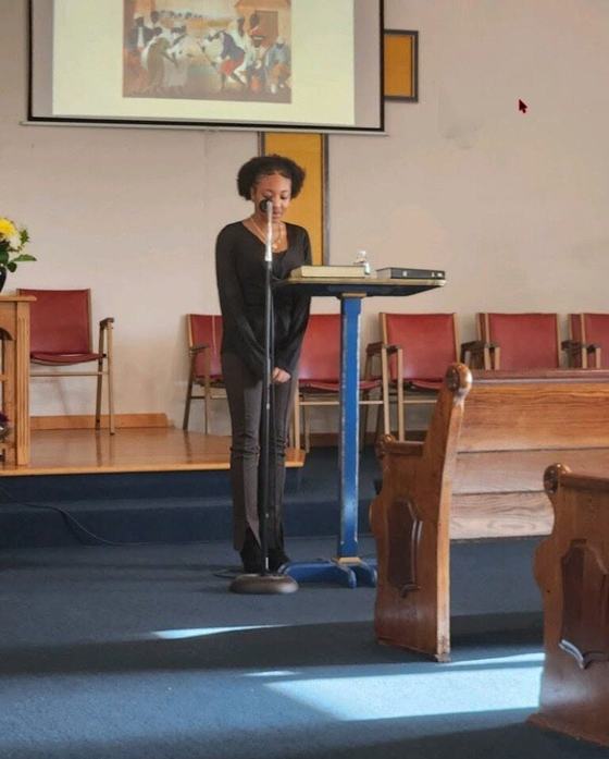 A young lady praying at the front of the sanctuary